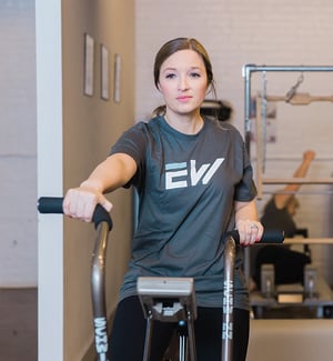 Personal training client performing cardio on an Airdyne bike at a physical therapy clinic gym.