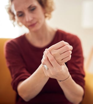 Person holding their wrist in pain.