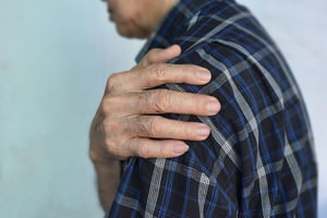 Person holding their shoulder due to discomfort.