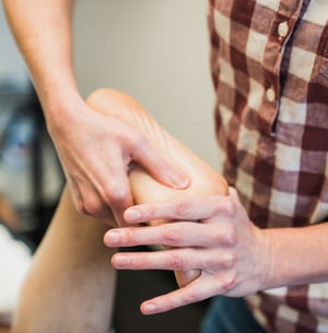 Close-up of a physical therapist providing manual therapy to the foot to improve mobility.