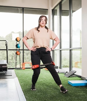 Woman performing lateral band walk exercise during personal training session at EW Motion Therapy.