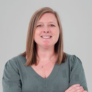 EW Motion Therapy Provider Liaison Maribeth Butts poses smiling for a headshot, wearing a green knit top.