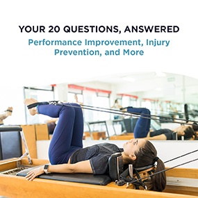 Woman lying on a Pilates reformer performing a resistance exercise with straps in a studio, representing EW Motion Therapy's free guide on Pilates benefits, modifications, and whether it's right for you